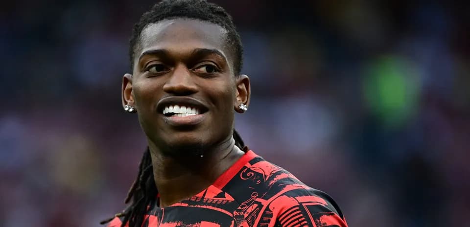 Player smiling in red and black patterned jersey