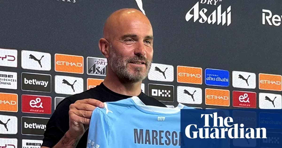 Coach holding a Manchester City jersey at press conference