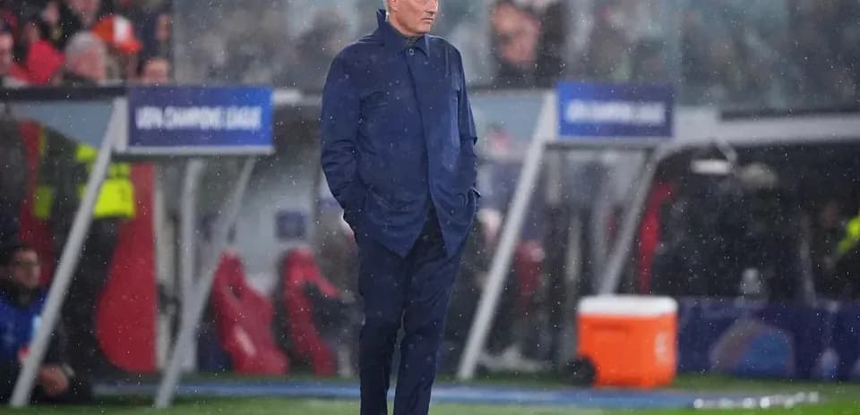 Manager observing match in rainy conditions