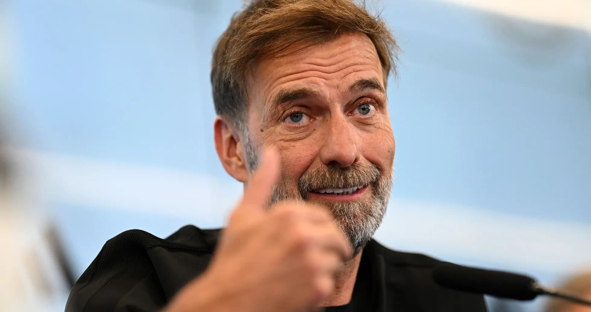 Manager giving thumbs up at press conference