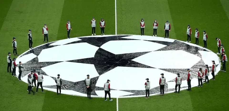 Ground staff setting up Champions League logo on pitch