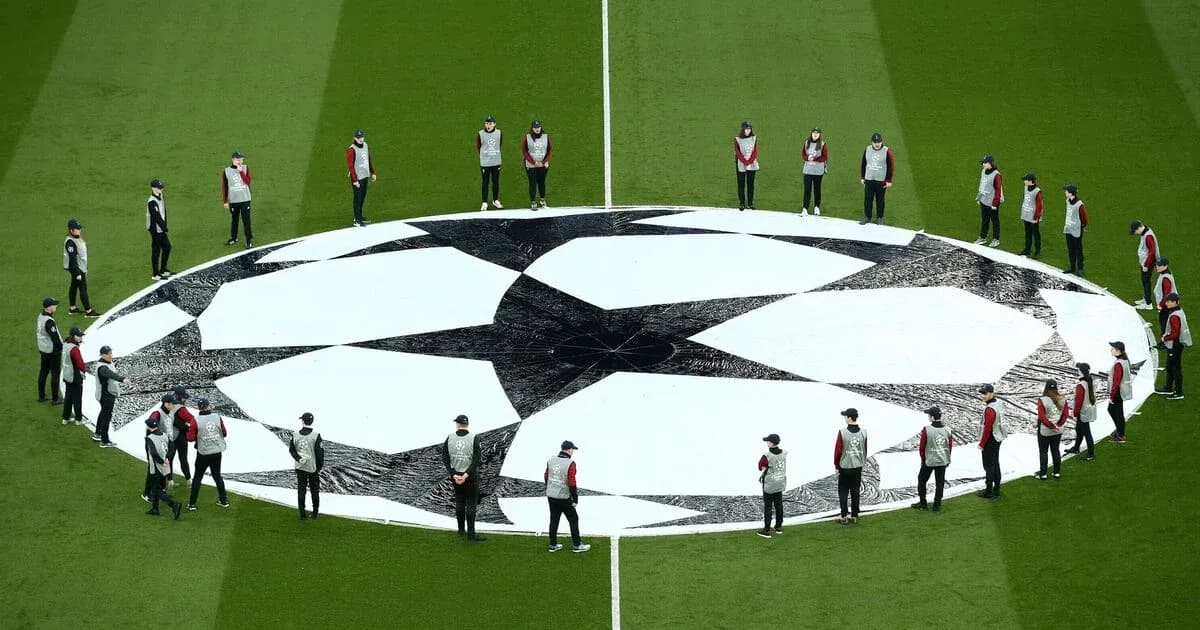 Ground staff setting up Champions League logo on pitch