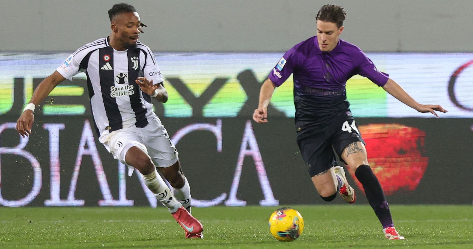 Juventus player challenging Fiorentina opponent