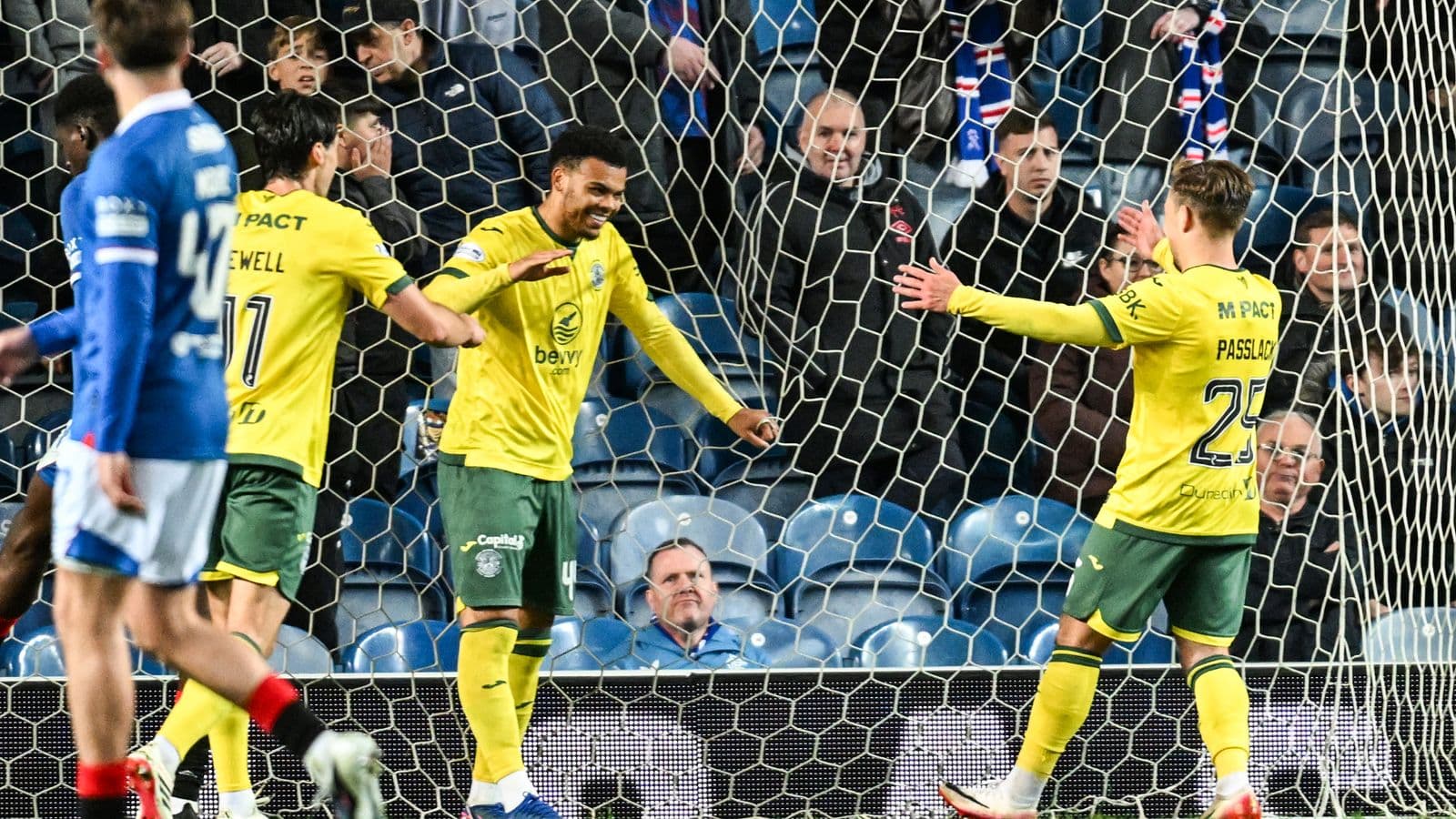 Players celebrating a goal in front of fans