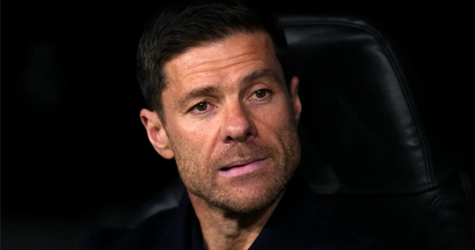 Coach seated on bench during match