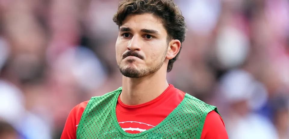 Player in green training bib on sidelines