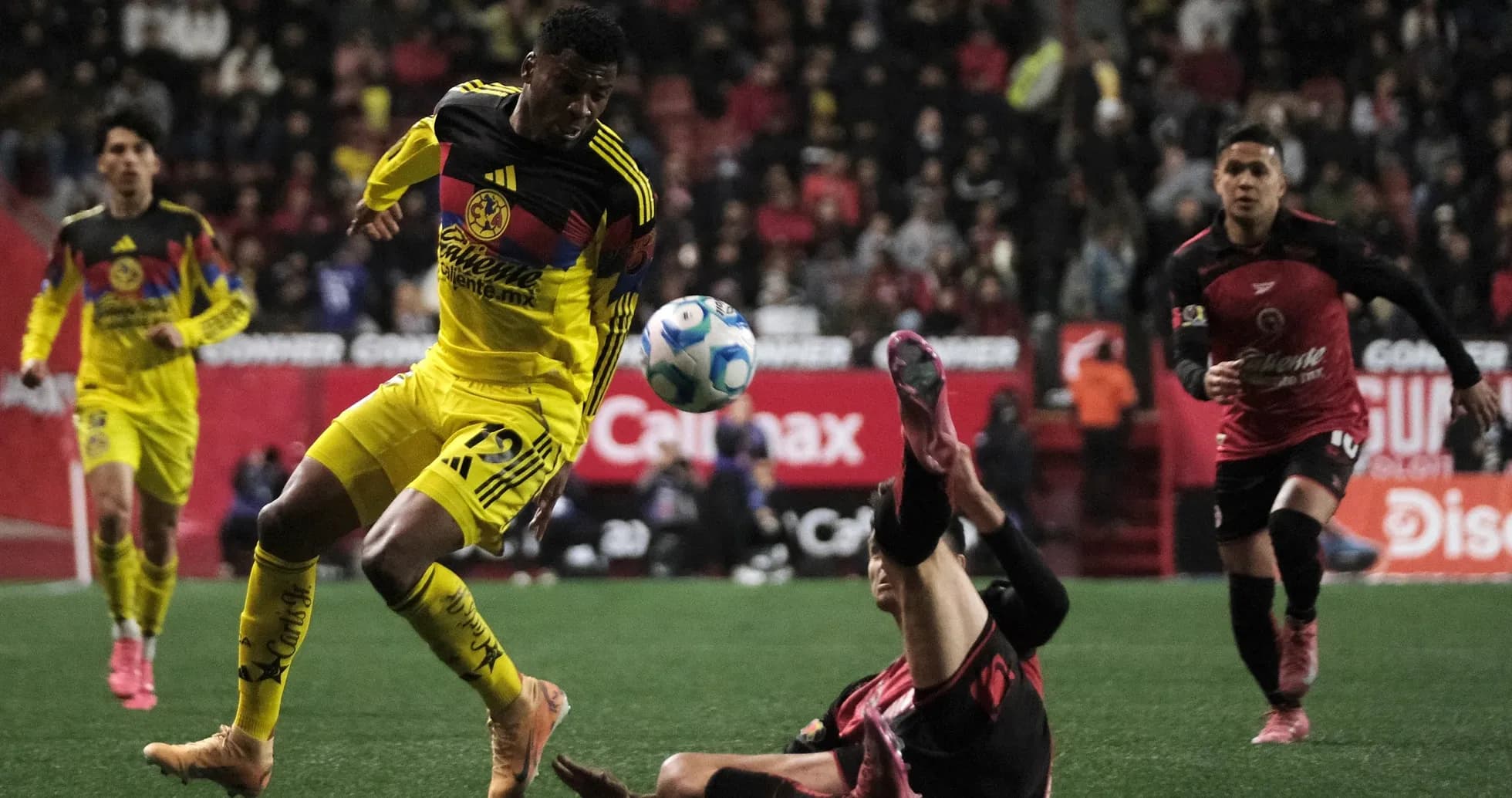 Club America player dribbling past opponent