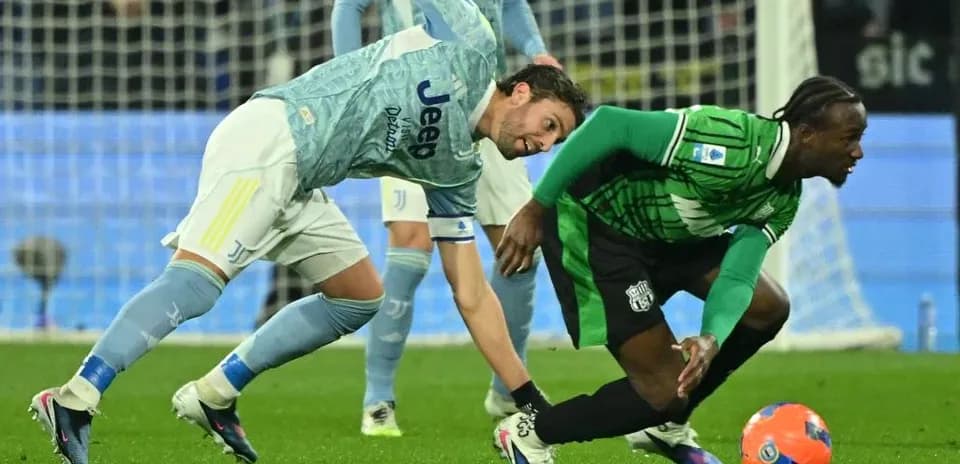 Juventus player tackling Sassuolo opponent during match