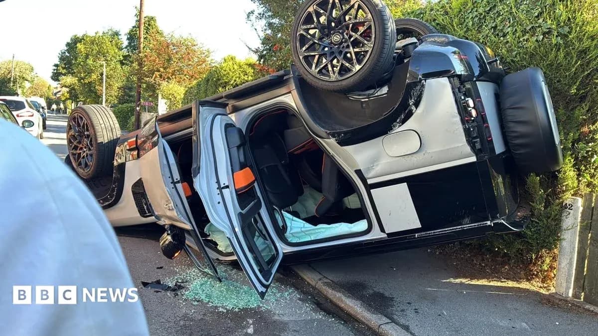 Upside-down sports car on roadside with broken glass