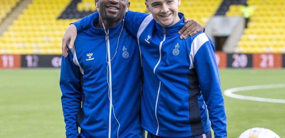 Two players posing together on the football pitch