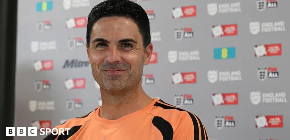 Coach smiling during press conference backdrop