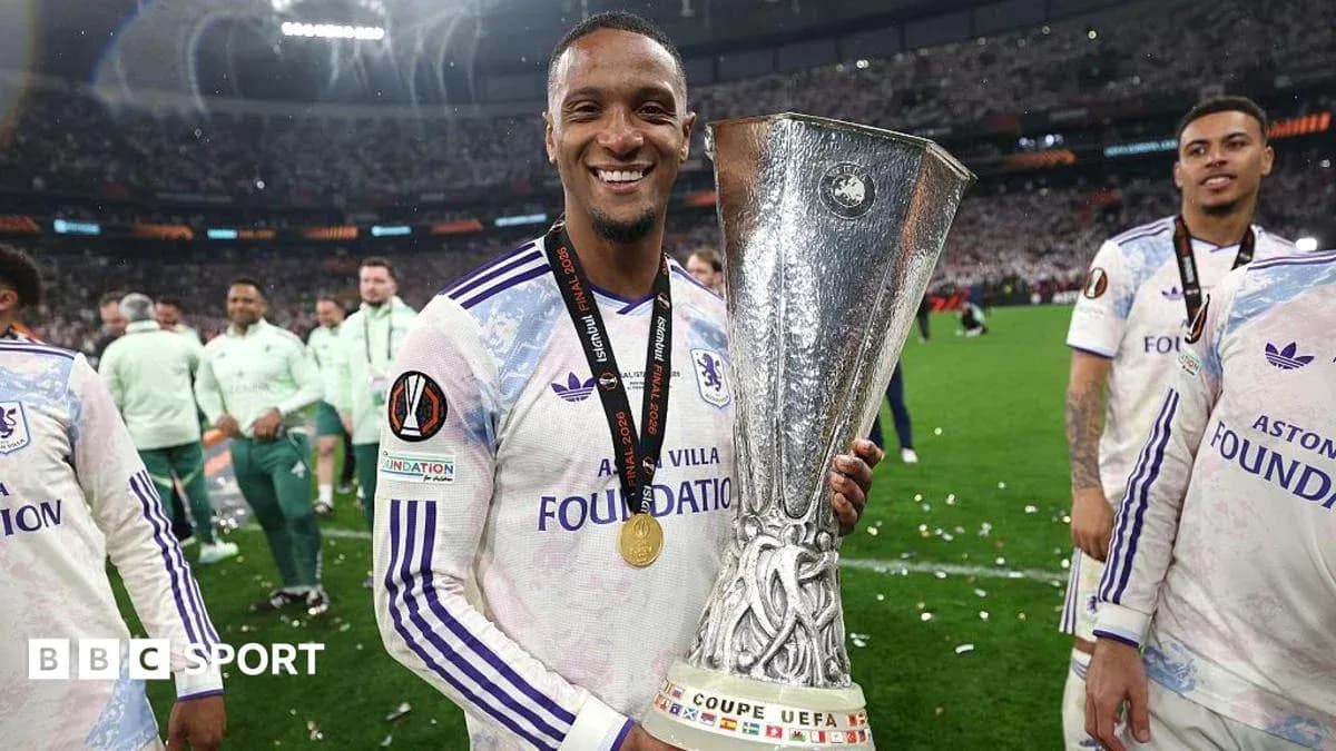 Player holding UEFA trophy with teammates celebrating