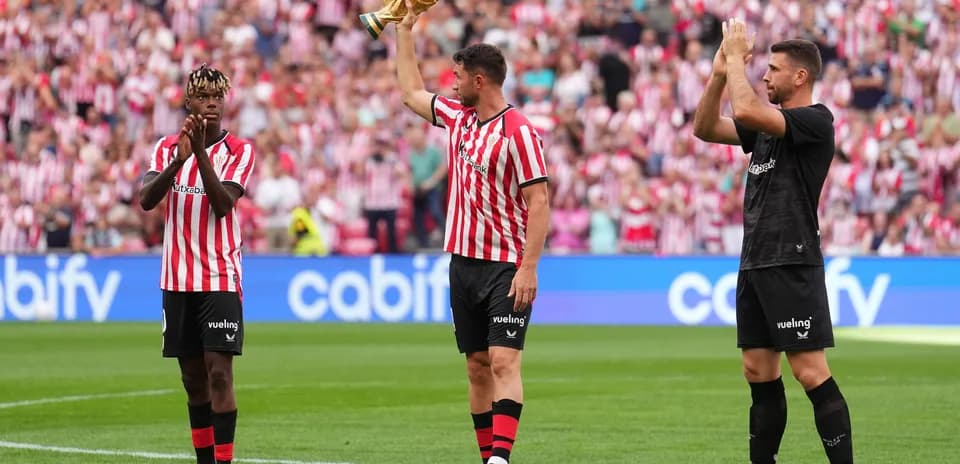 Athletic Bilbao players celebrating with trophy and applauding fans