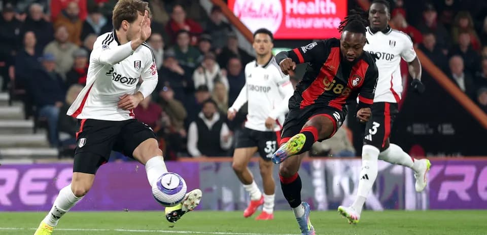 Fulham player challenging Bournemouth opponent for the ball