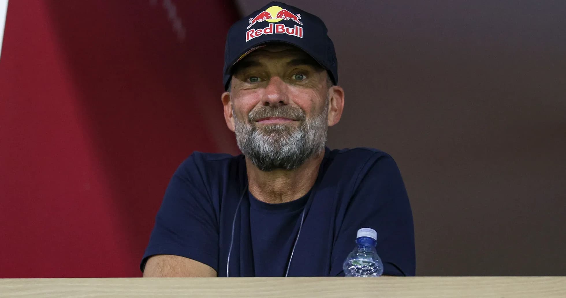Man wearing Red Bull cap observing from balcony