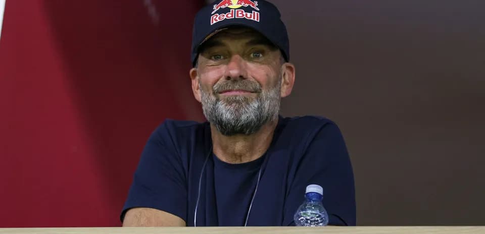 Man wearing Red Bull cap observing from balcony