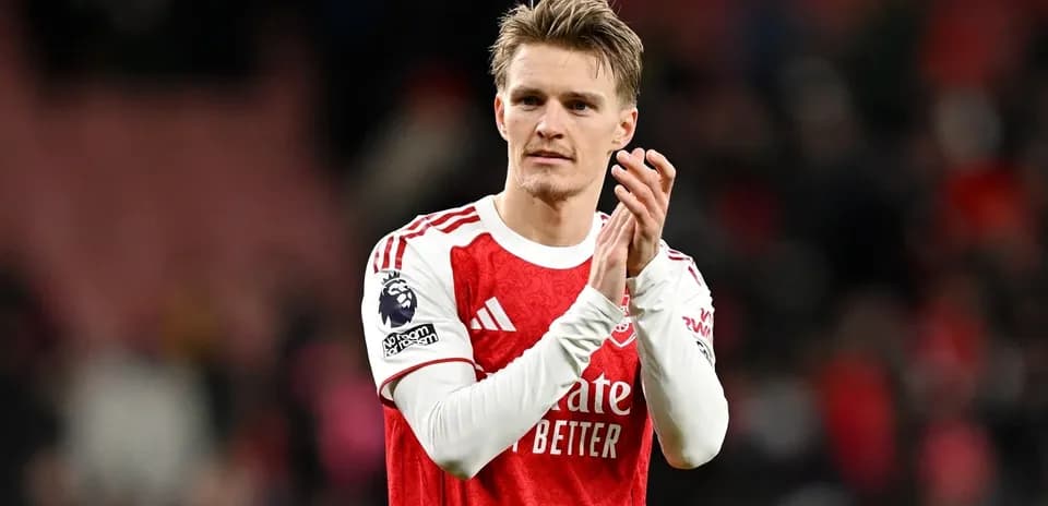 Player applauding fans after match in Arsenal kit