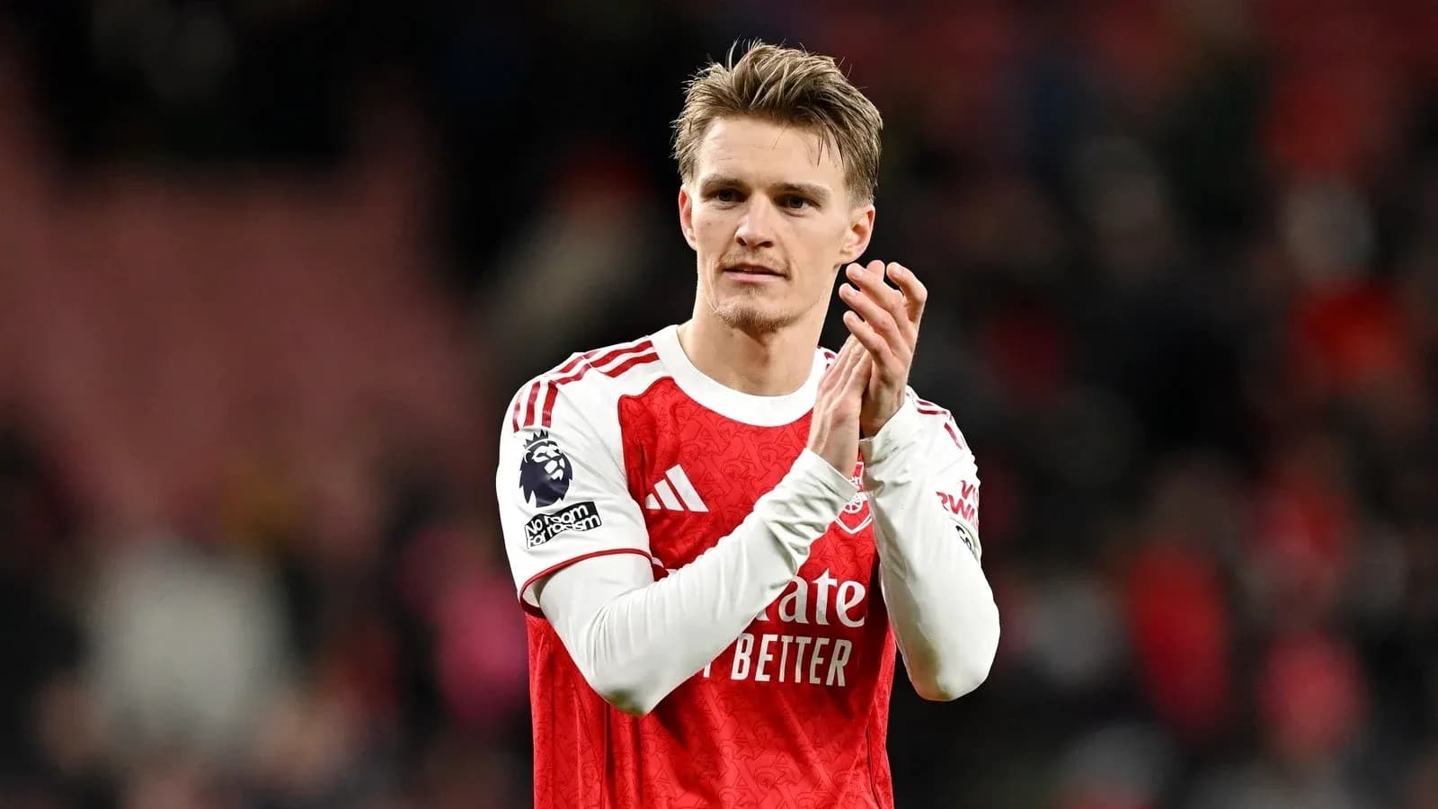 Player applauding fans after match in Arsenal kit