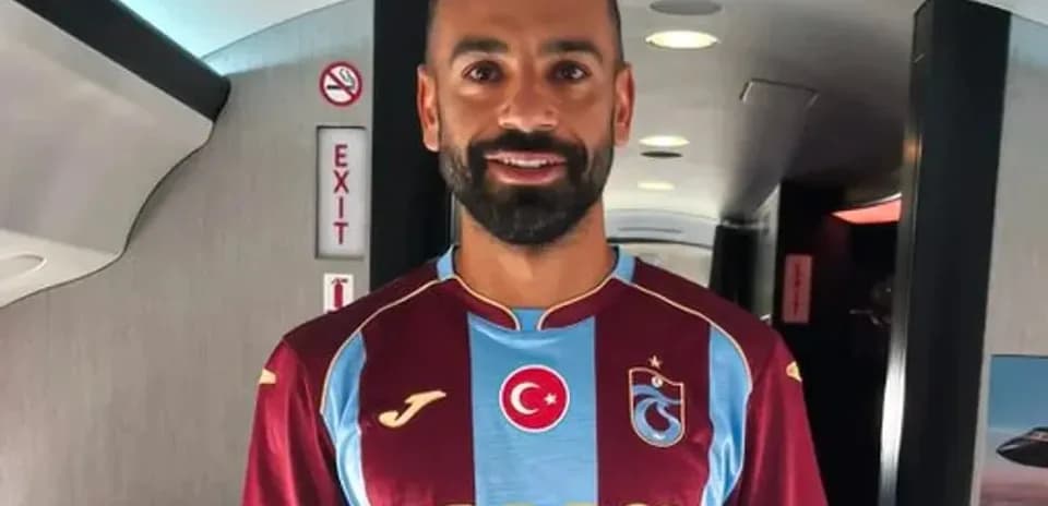 Player wearing Trabzonspor jersey inside aircraft