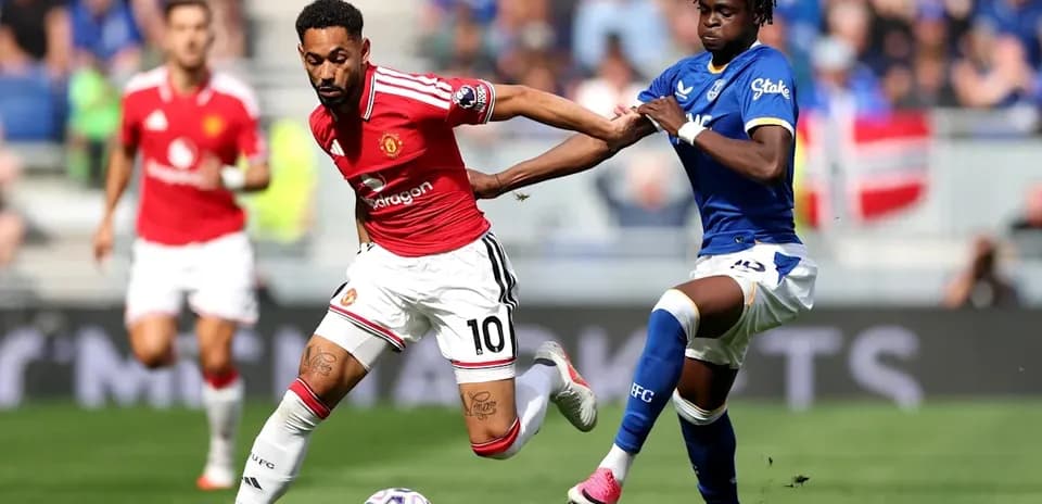 Player in red dribbling past defender in blue