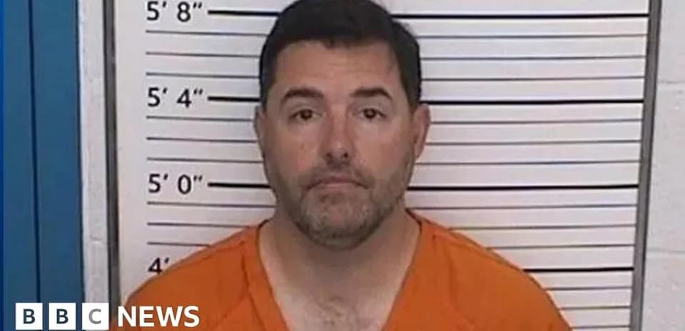 Mugshot of a man in orange jumpsuit