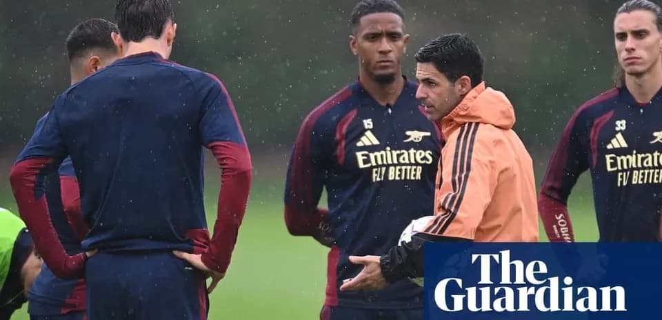 Manager speaking to players during rainy training session