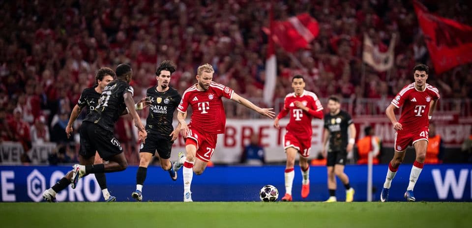 Bayern player dribbling past PSG defenders