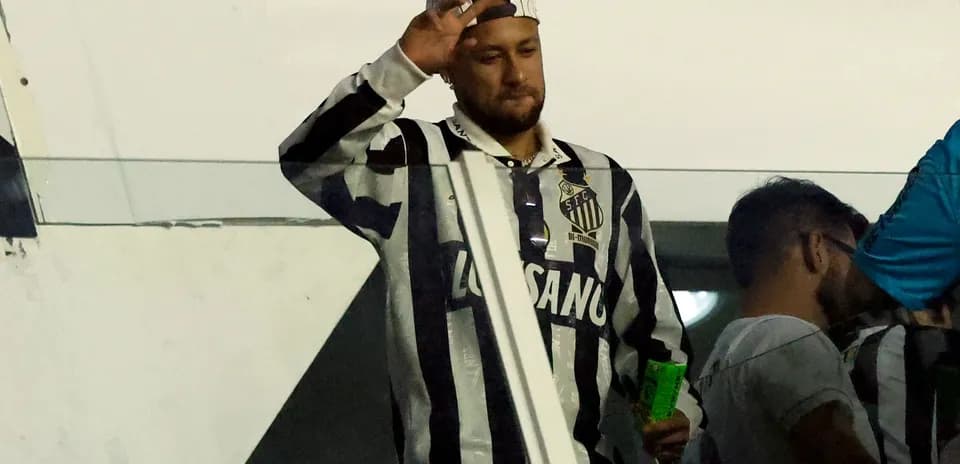 Man waving in Santos FC jersey at stadium