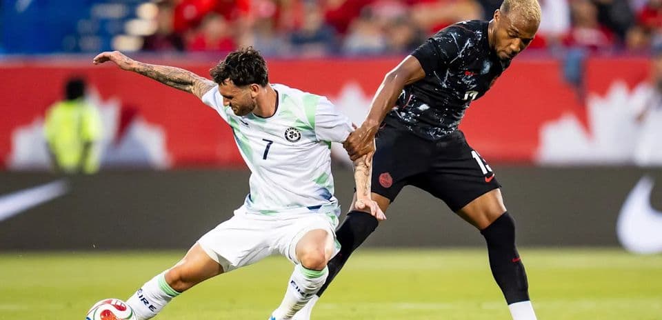 Two soccer players competing for the ball