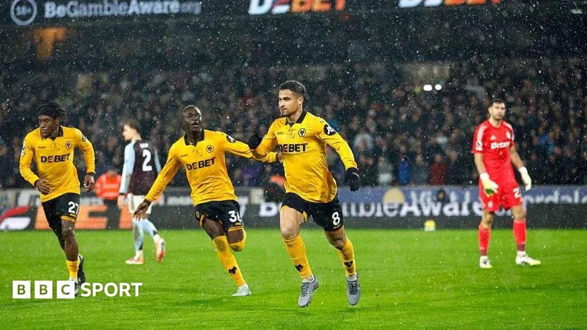 Player celebrating goal with teammates in rain