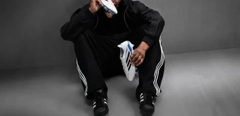 Athlete sitting on floor holding sports shoe