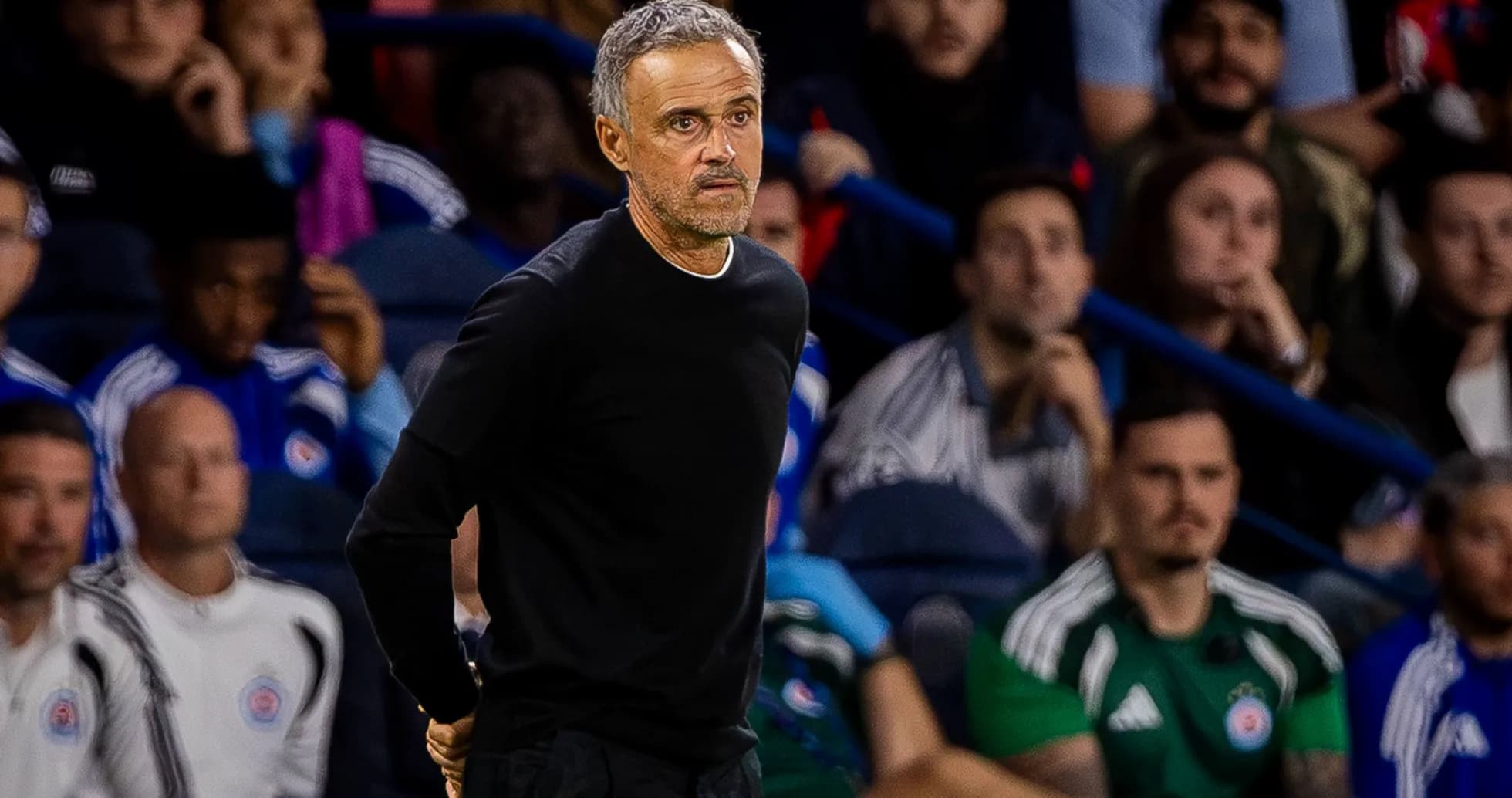 Coach observing match from the sidelines with fans