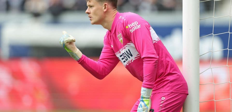 Goalkeeper in pink uniform signaling during match