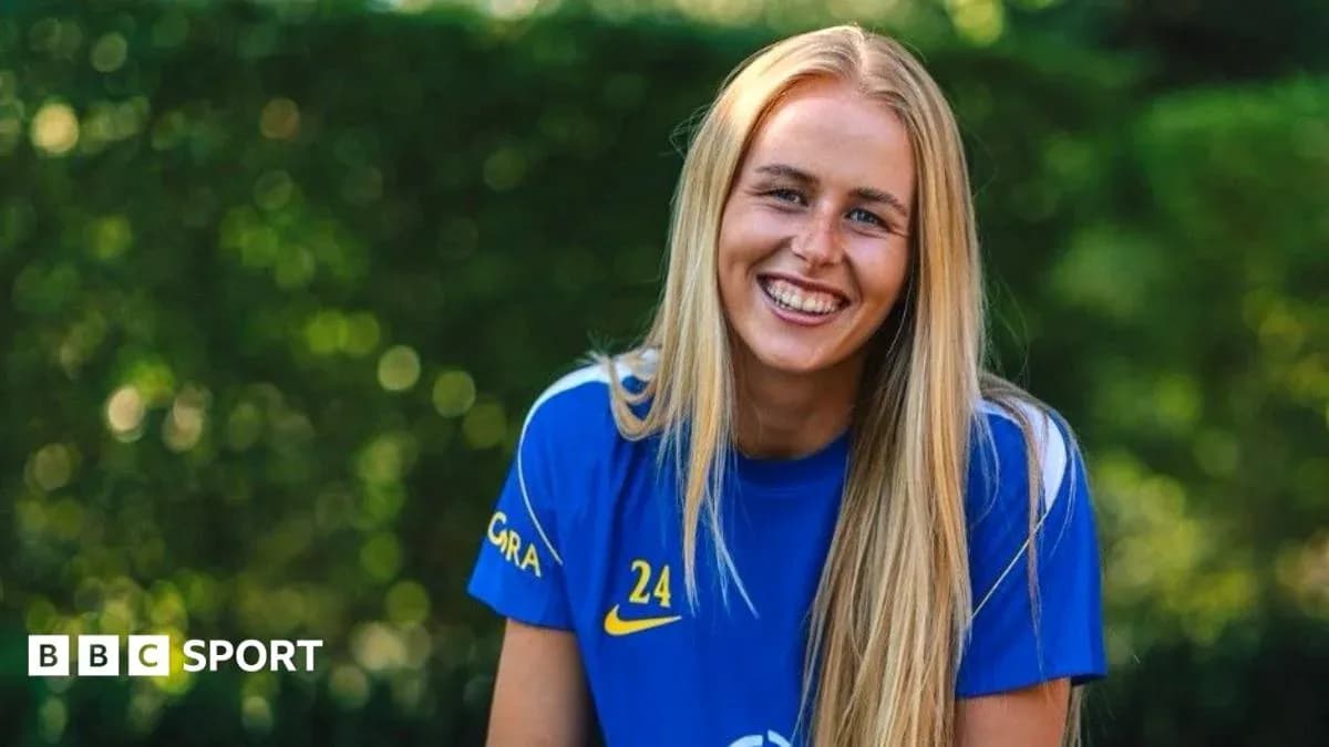 Player smiling in blue team jersey outdoors