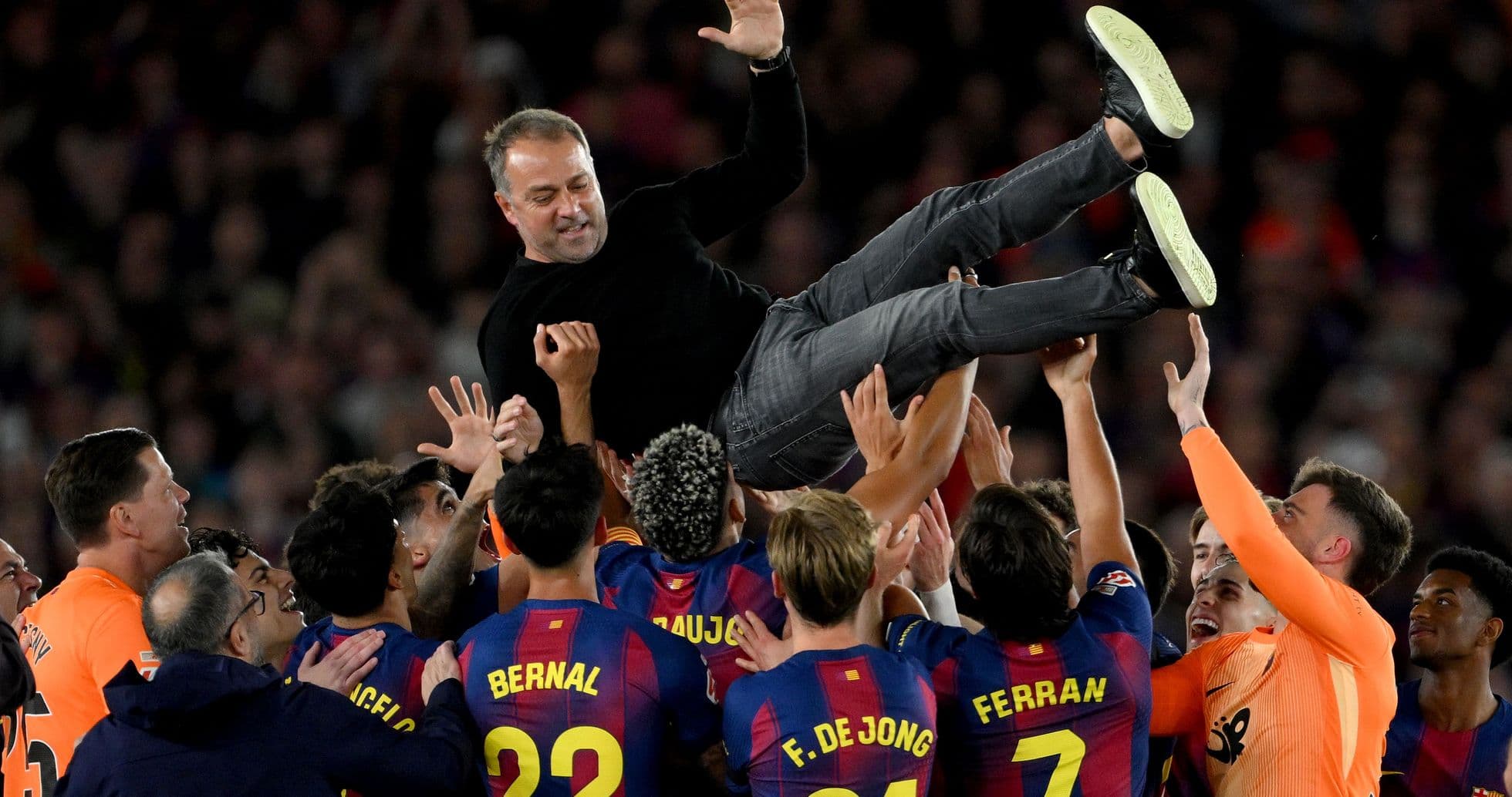 Barcelona players lifting their coach in celebration