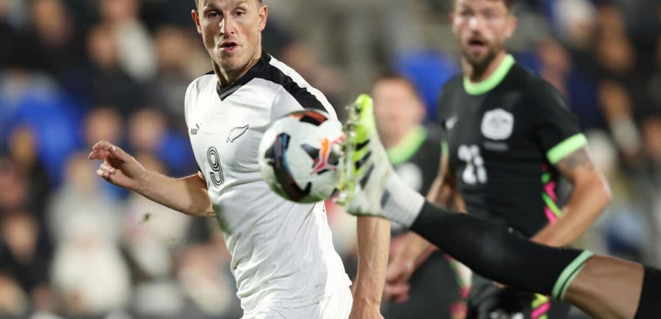 Player kicking ball while another player reacts