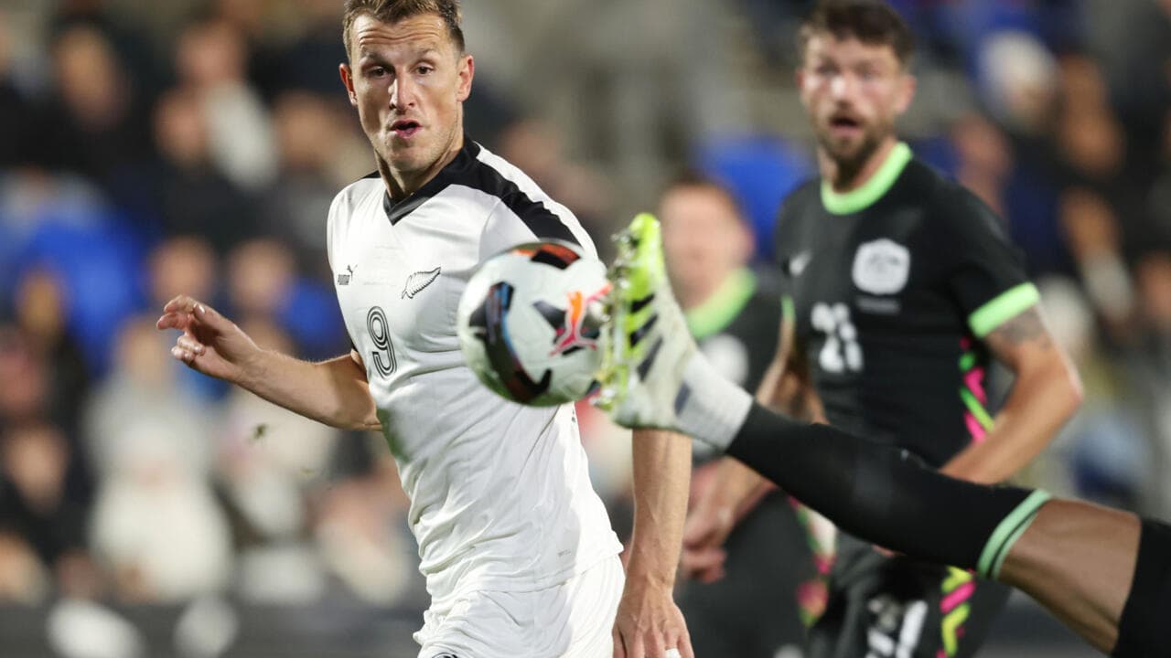 Player kicking ball while another player reacts