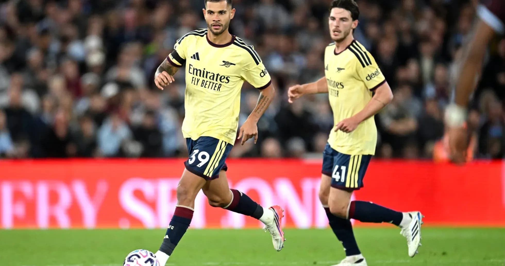 Two Arsenal players running during a match