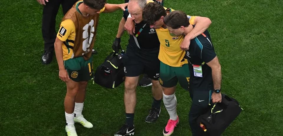 Player being assisted off field by staff members