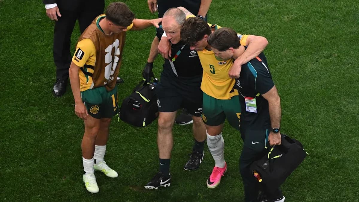 Player being assisted off field by staff members