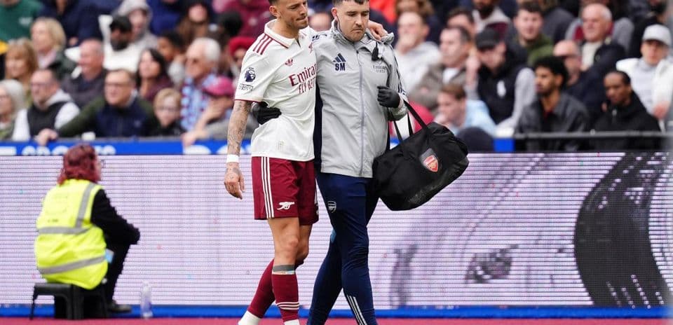 Player receiving assistance from medical staff on pitch