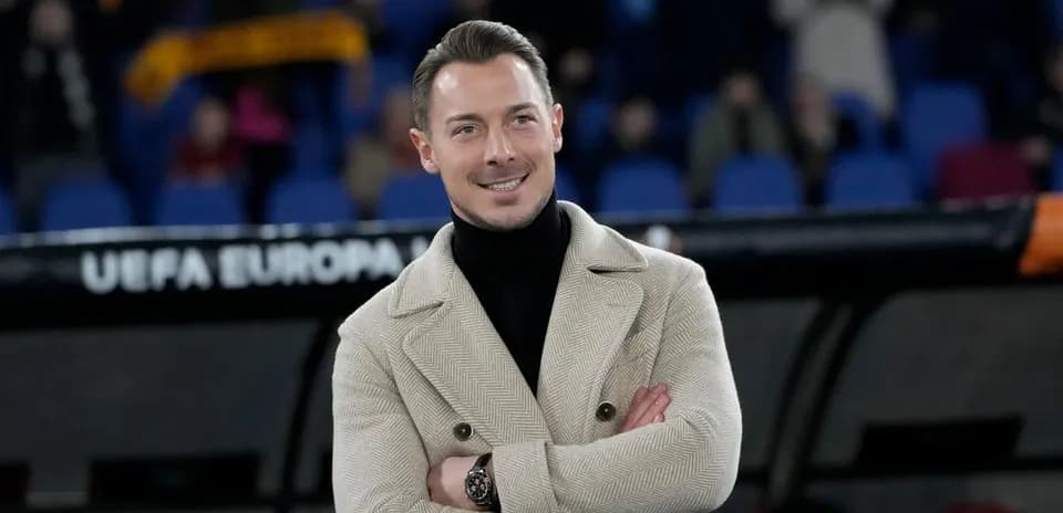 Man in stylish coat smiling at the stadium