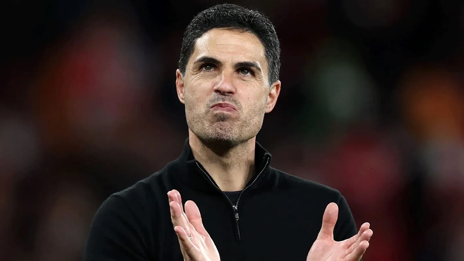Coach applauding during a match at the stadium