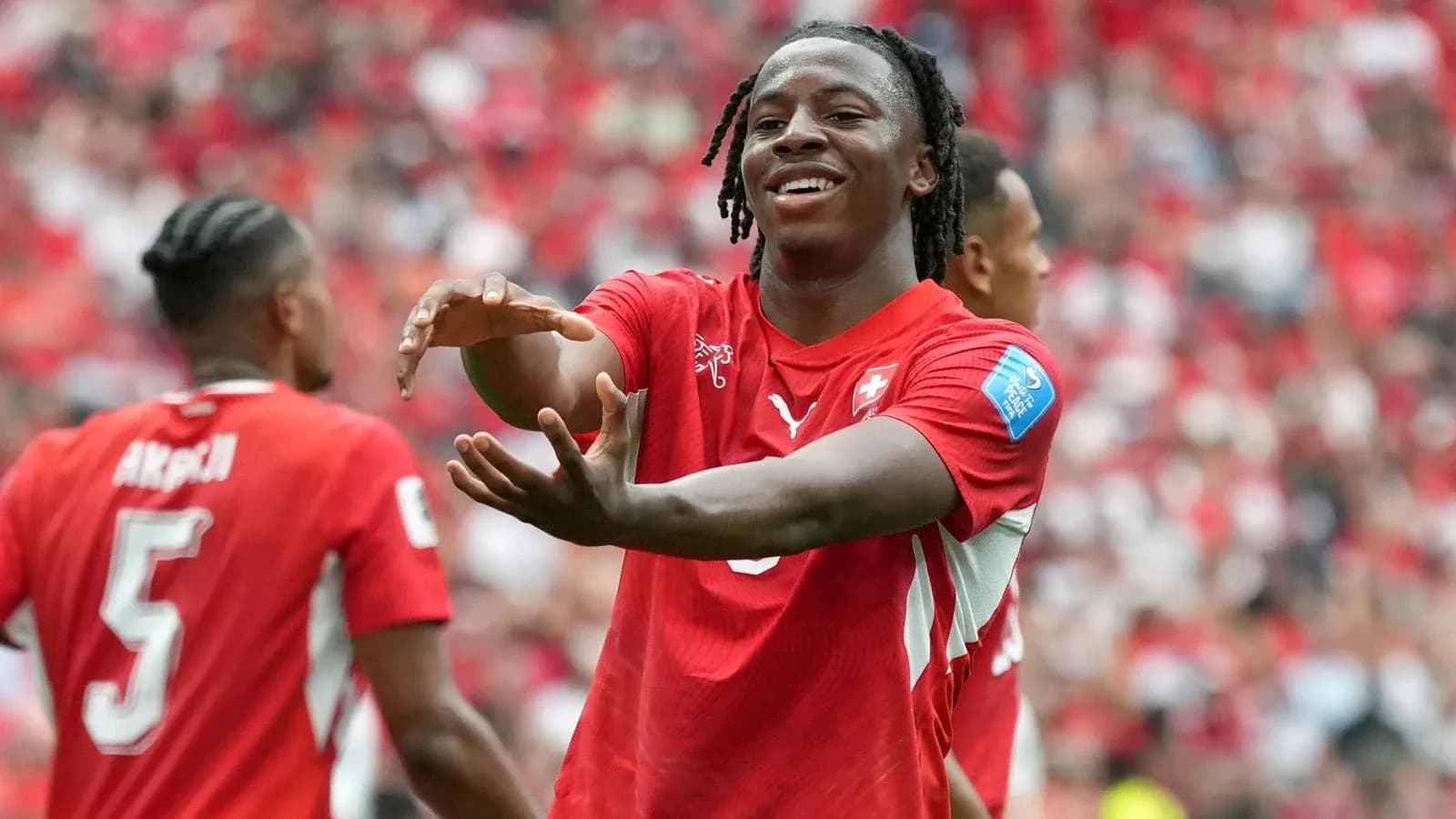 Player celebrating a goal with teammates in stadium