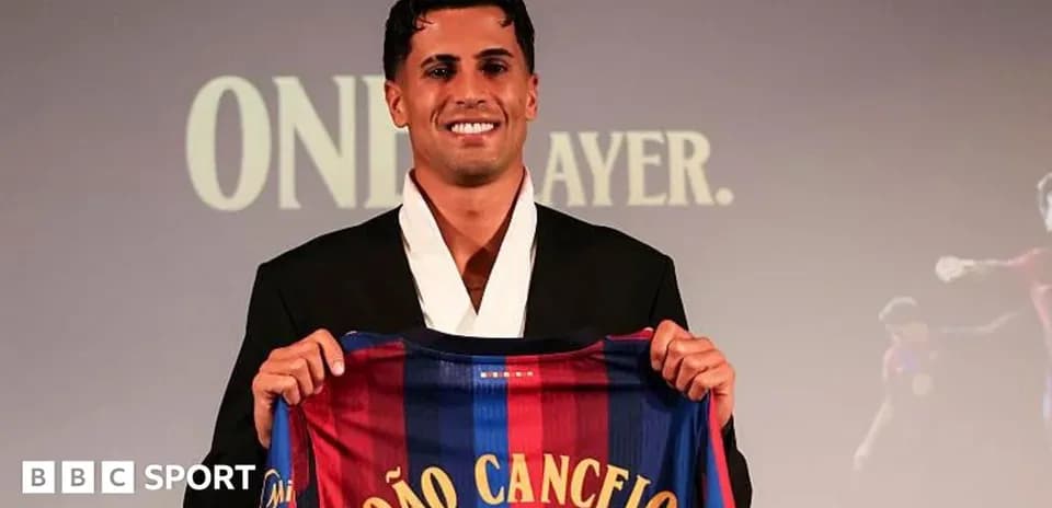 João Cancelo holding FC Barcelona jersey at presentation