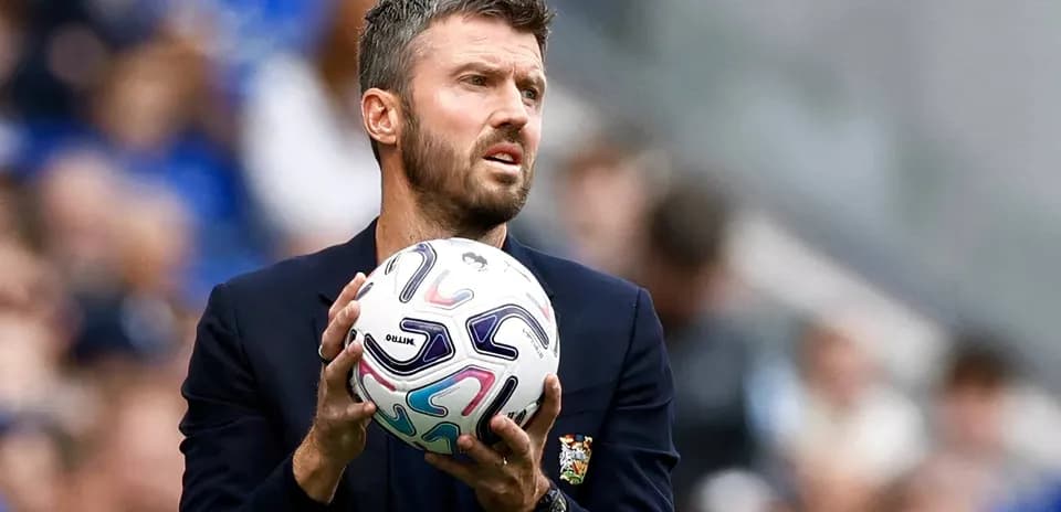 Coach holding a soccer ball on the sideline