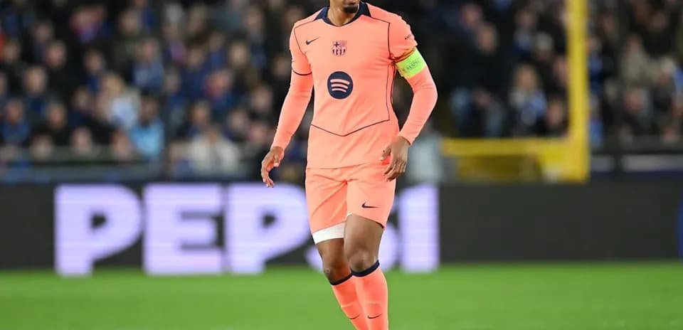 Player in pink kit with ball on the field