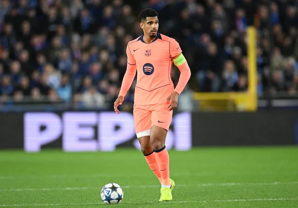 Player in pink kit with ball on the field