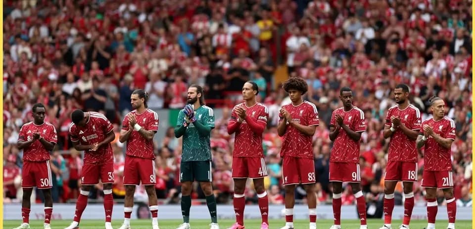 Liverpool players standing in line, applauding fans