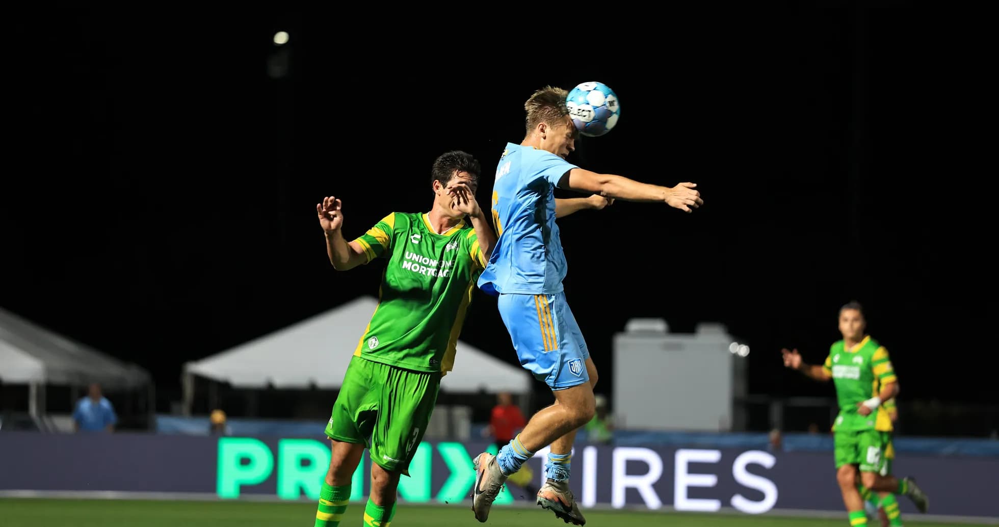Player heading the ball during match